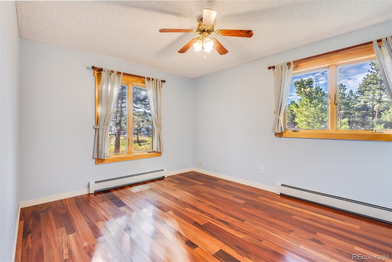 7572 Surrey Drive Morrison, CO 80465 - Photo 18 of 38 a view of an empty room with window and wooden floor