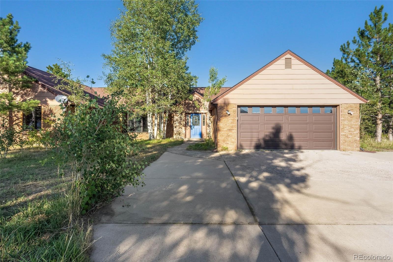 7572 Surrey Drive Morrison, CO 80465 - Photo 2 of 38 a front view of a house with a yard and garage