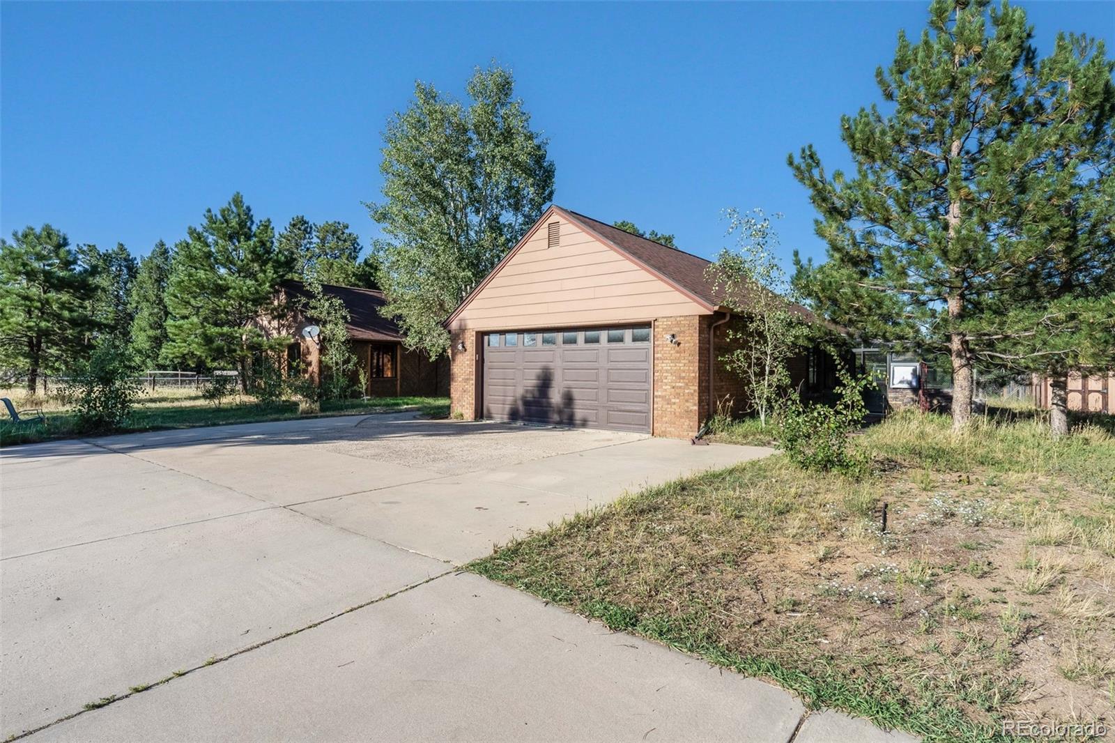 7572 Surrey Drive Morrison, CO 80465 - Photo 4 of 38 a front view of a house with a yard and garage