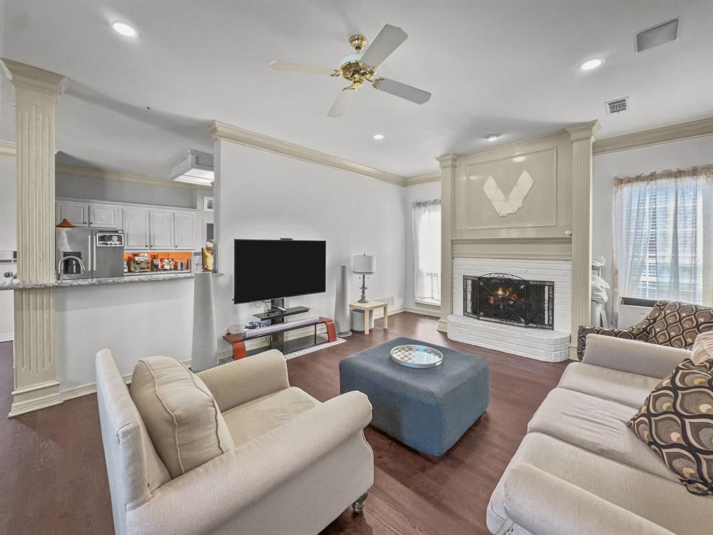 3405 Snidow Drive Plano, TX 75025 - Photo 14 of 24 Living area with healthy amount of natural light, ornamental molding, ceiling fan, decorative columns, and dark wood-type flooring