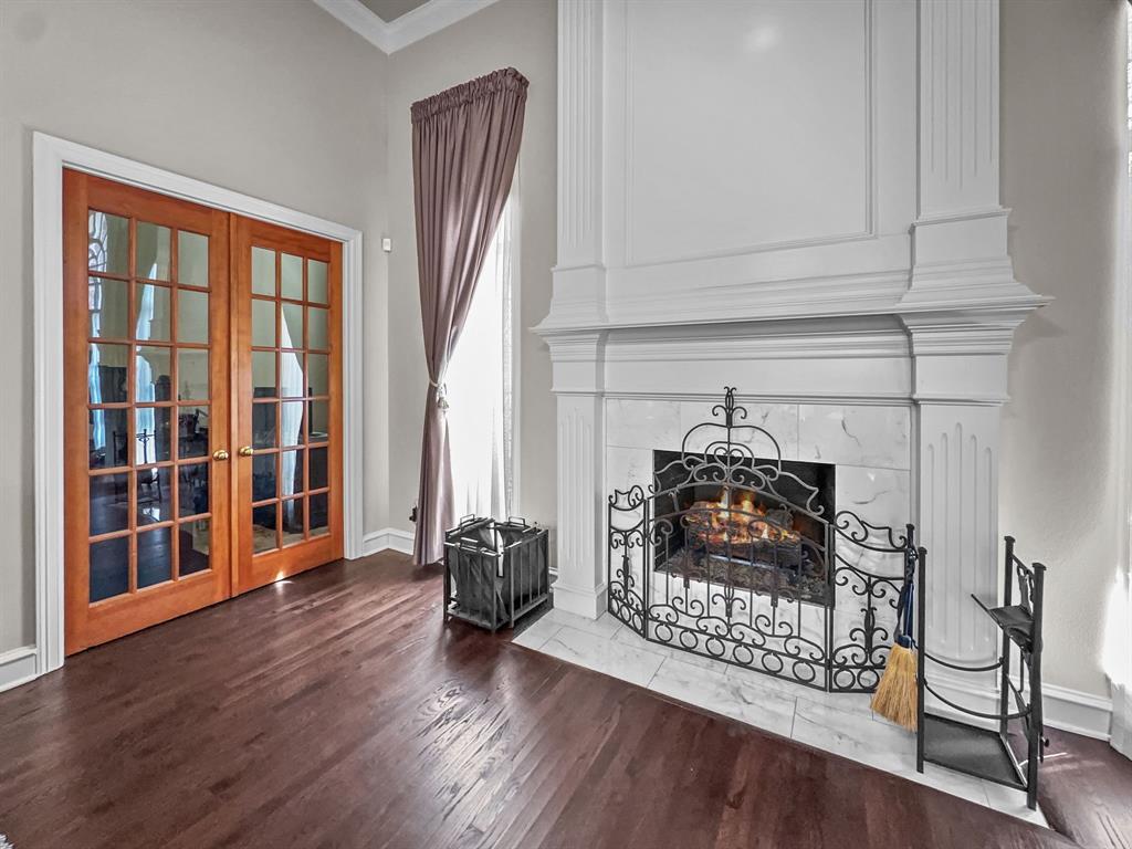 3405 Snidow Drive Plano, TX 75025 - Photo 16 of 24 Detailed view of french doors, crown molding, a fireplace, and wood finished floors