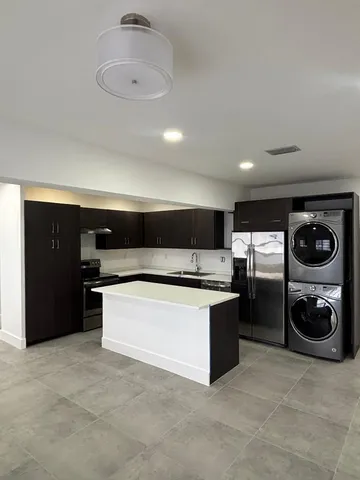 a kitchen with stainless steel appliances granite countertop a refrigerator and a stove
