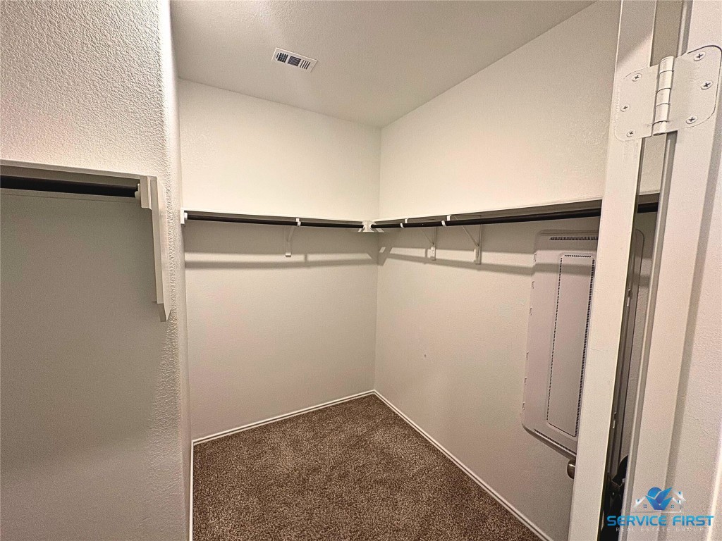 124 Rooster Way Jarrell, TX 76537 - Photo 13 of 27 a view of walk in closet with empty racks