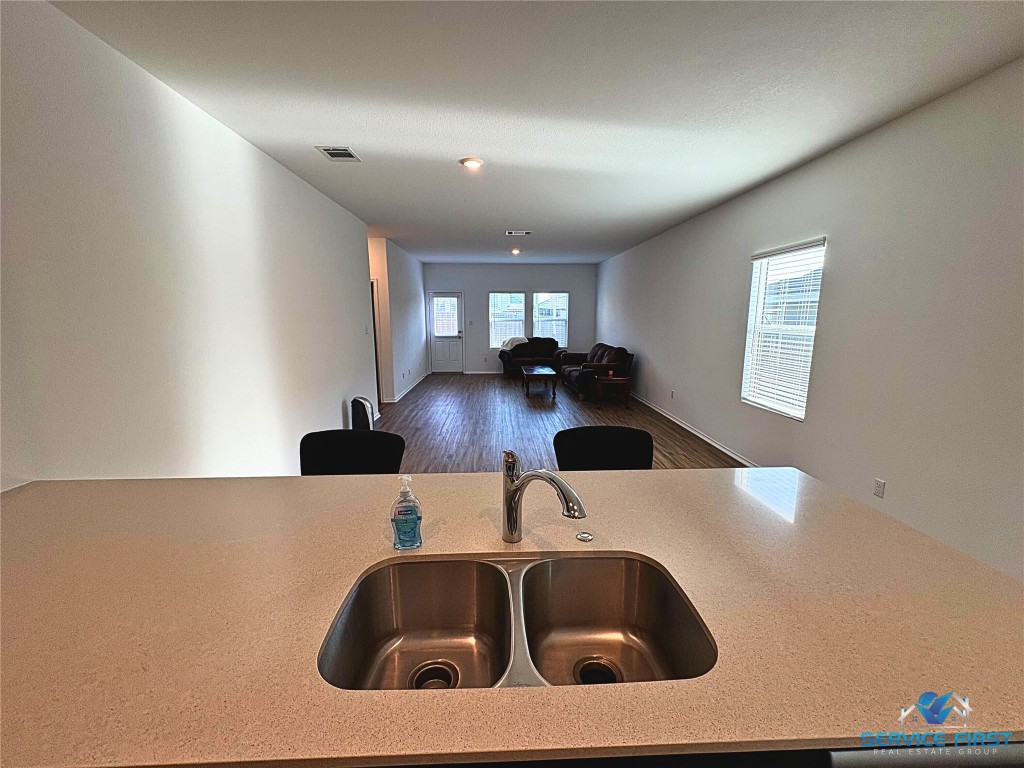 124 Rooster Way Jarrell, TX 76537 - Photo 27 of 27 a kitchen with a sink and a stove with wooden floor