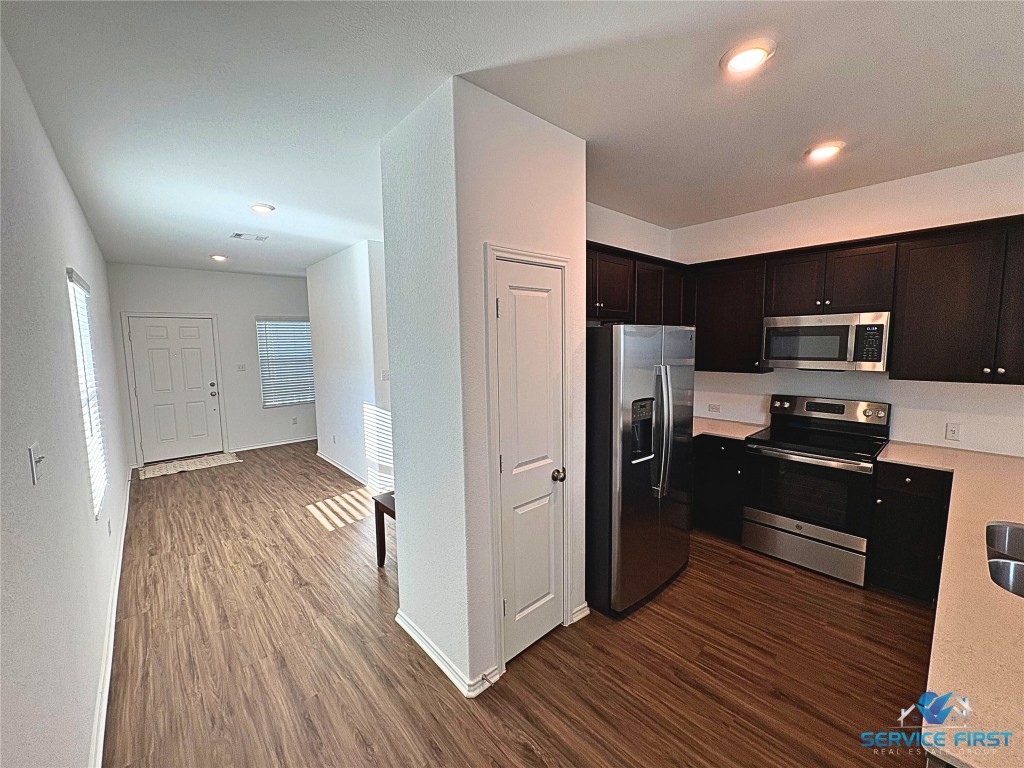 124 Rooster Way Jarrell, TX 76537 - Photo 7 of 27 a kitchen with a refrigerator an oven and wooden floor