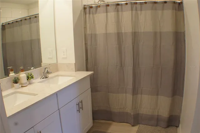 a bathroom with a sink shower and a mirror