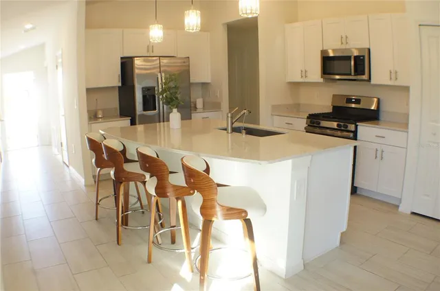 a kitchen with stainless steel appliances granite countertop a sink a stove and a refrigerator