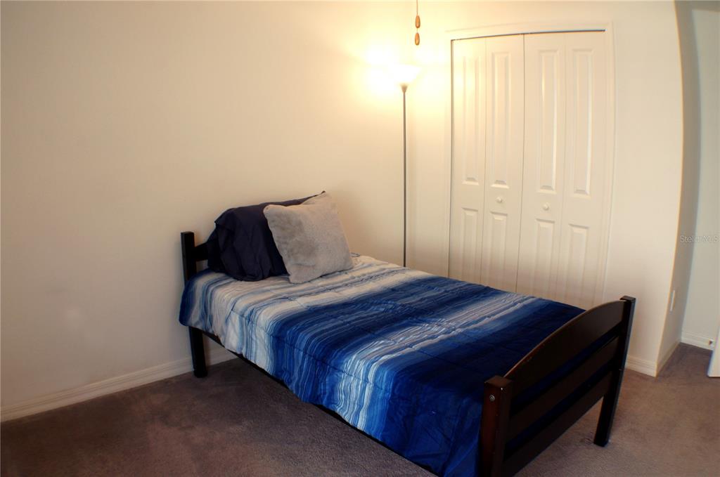 1714 Lanier Road Zephyrhills, FL 33541 - Photo 10 of 23 a bedroom with a bed and a mirror