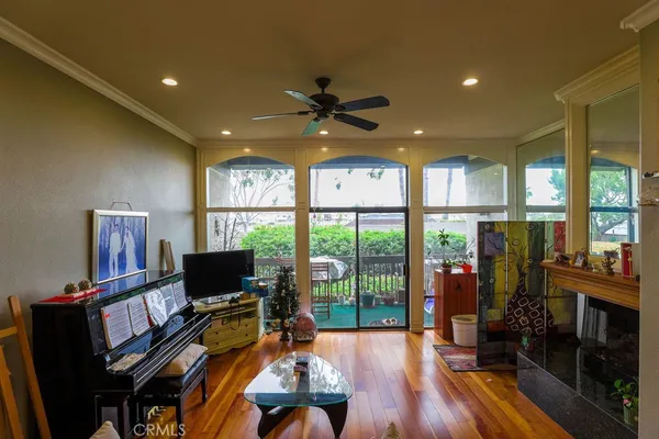 a living room with furniture a flat screen tv and a floor to ceiling window