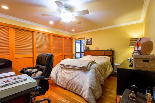 a bedroom with a bed and wooden floor