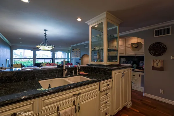 a kitchen with stainless steel appliances granite countertop a sink a stove oven a counter space and cabinets