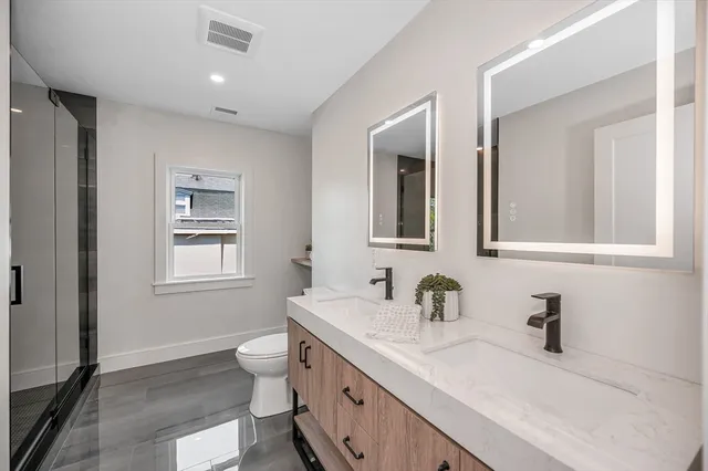 a bathroom with a sink double vanity and a toilet