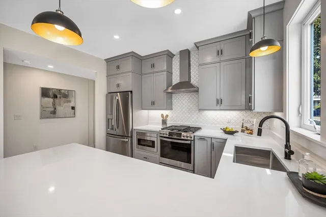 a kitchen with stainless steel appliances granite countertop a sink stove and refrigerator