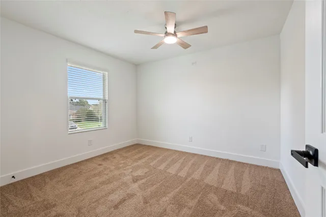 an empty room with a window and a fan