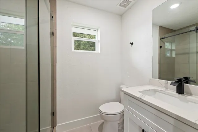 a bathroom with a sink a toilet and shower