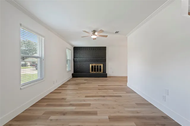 a view of an empty room with a window and a ceiling fan