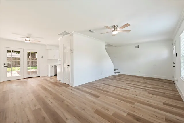 a view of empty room with wooden floor and ceiling fan