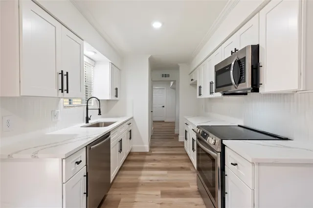 a kitchen with stainless steel appliances granite countertop a sink stove and microwave