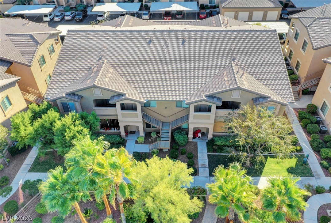 8985 South Durango Drive, Unit 2187 Las Vegas, NV 89113 - Photo 42 of 73 An aerial perspective reveals a multi-unit structure featuring tiled roofing and lush green landscaping.