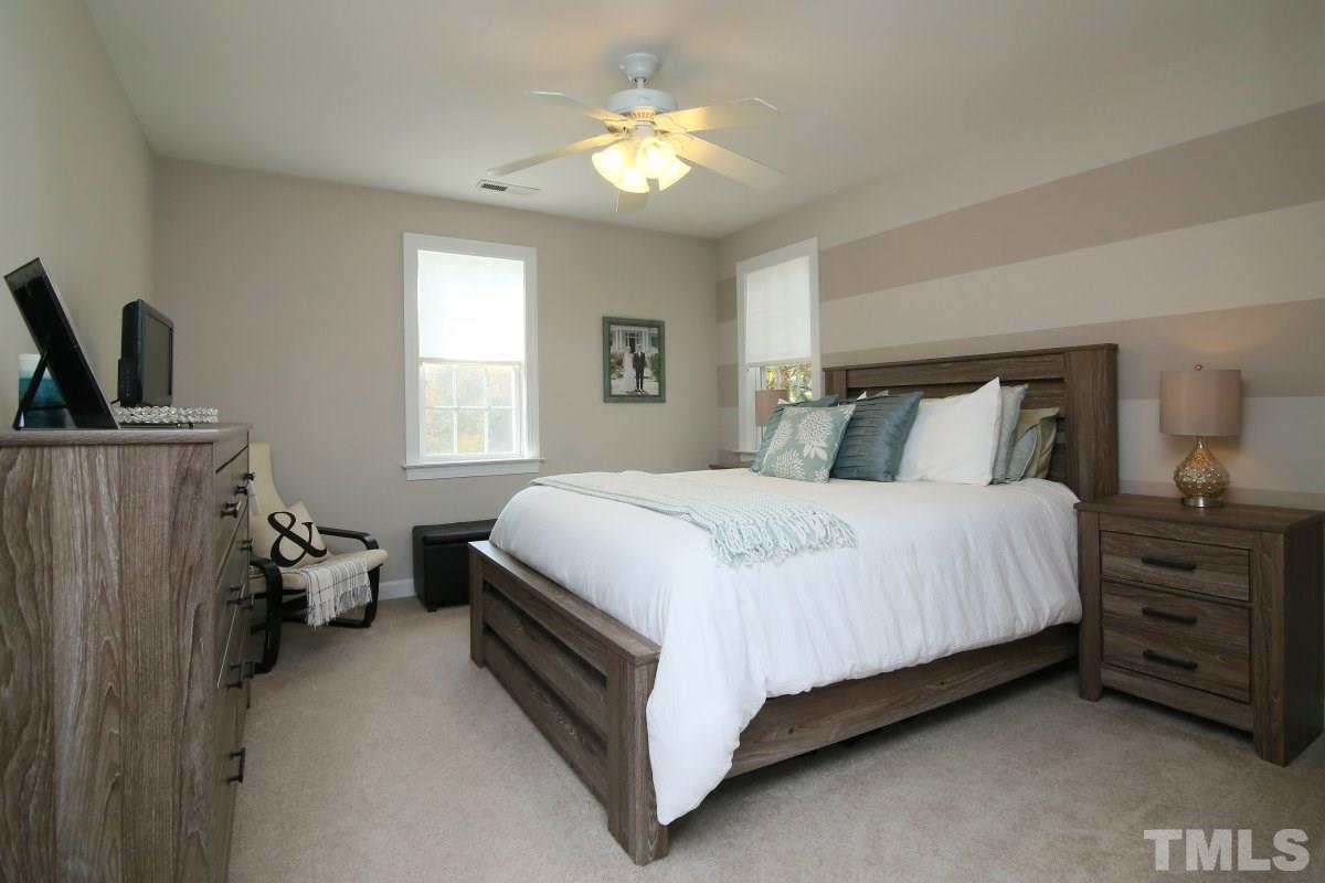9212 Pennythorne Court Raleigh, NC 27615 - Photo 19 of 25 a bedroom with a bed and a chandelier