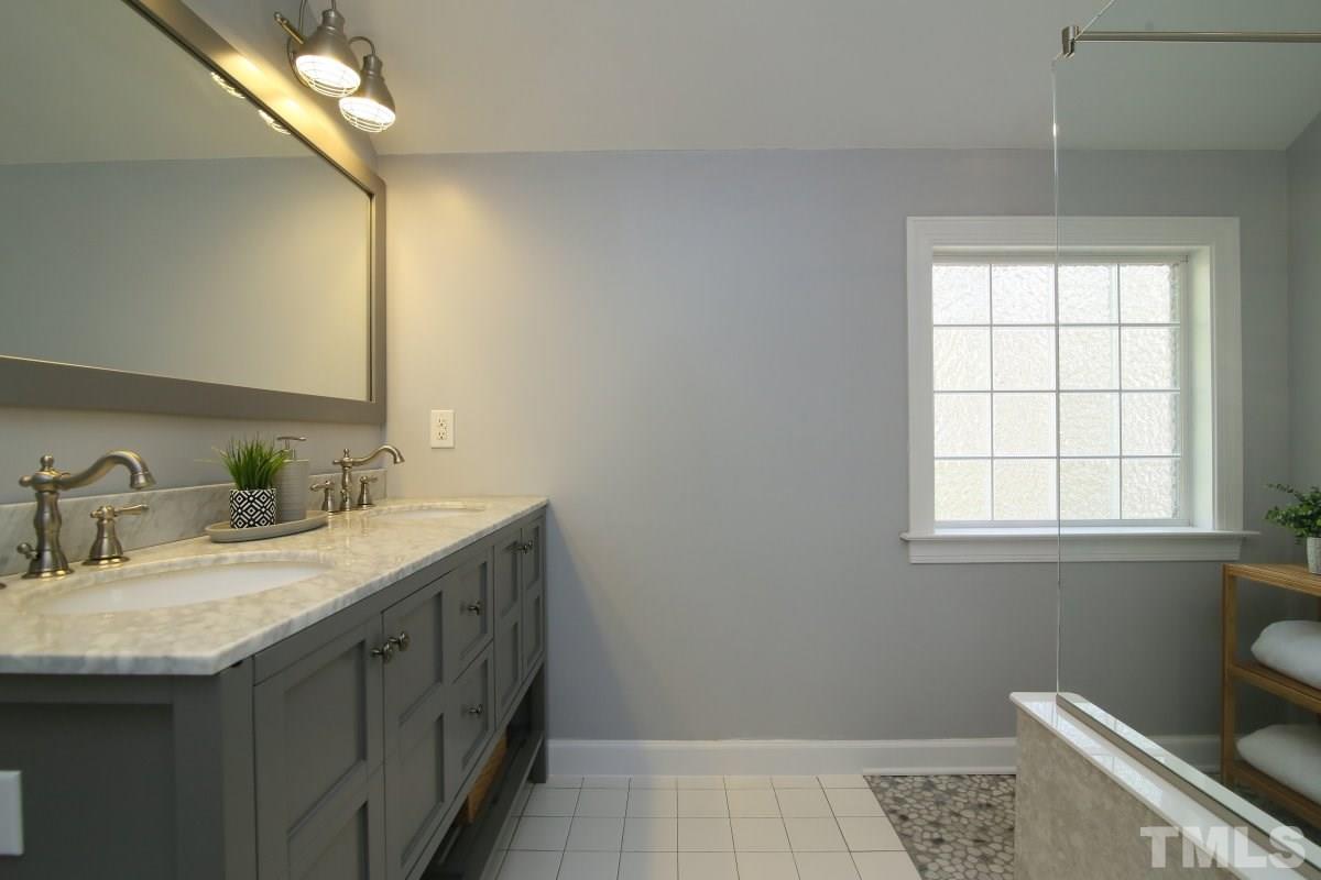 9212 Pennythorne Court Raleigh, NC 27615 - Photo 21 of 25 a bathroom with a granite countertop sink a toilet and a mirror