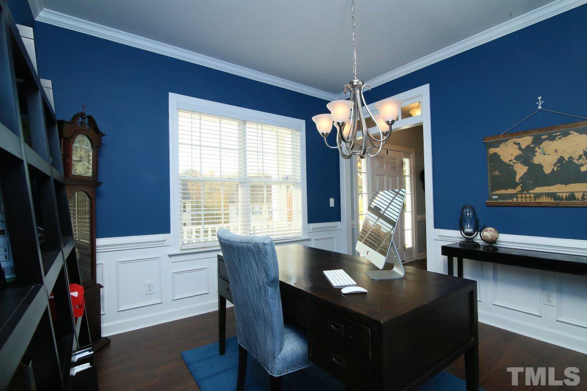 9212 Pennythorne Court Raleigh, NC 27615 - Photo 10 of 25 a living room with furniture a flat screen tv and a floor to ceiling window