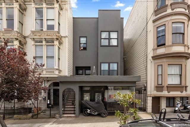 a front view of a building and car parked