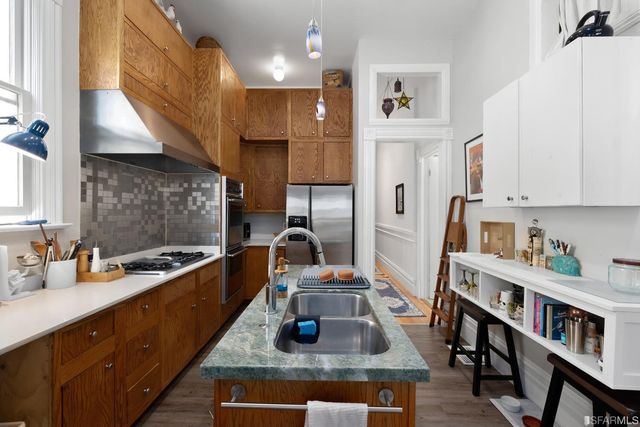 a kitchen with stainless steel appliances granite countertop a sink stove and refrigerator