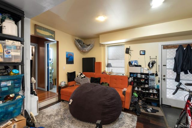 a living room with furniture a flat screen tv and floor to ceiling window