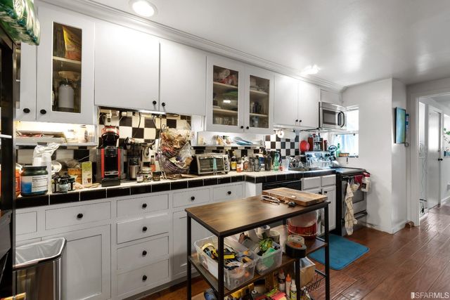a kitchen with stainless steel appliances kitchen island granite countertop a table and chairs in it