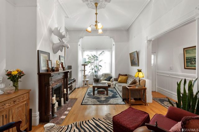 a living room with furniture a chandelier and a dining table