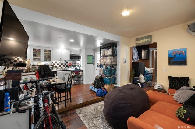 a living room with furniture a flat screen tv and floor to ceiling window
