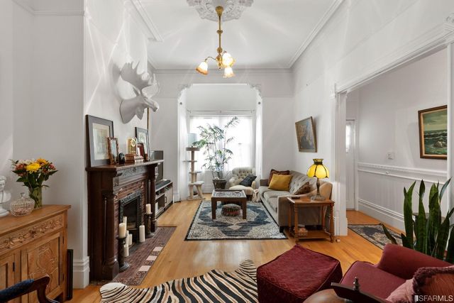 a living room with furniture a fireplace a chandelier and a flat screen tv
