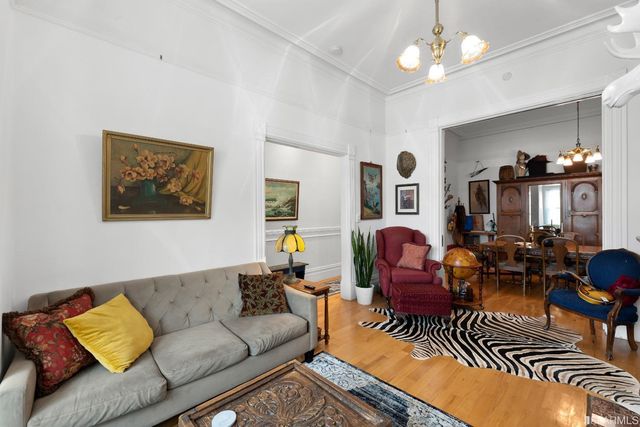 a living room with furniture a chandelier and a dining table