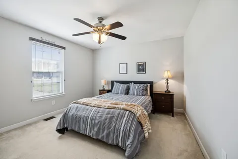a bedroom with a bed and a ceiling fan