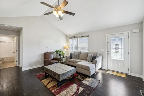 a living room with furniture a wooden floor and a chandelier