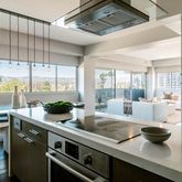 a living room with stainless steel appliances with large windows