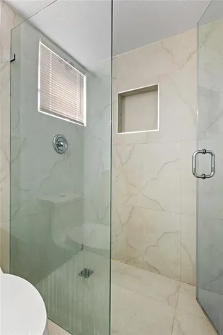 a bathroom with a toilet and a shower