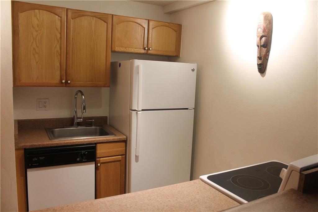 7204 Ryan Gulch Road, Unit 7204 Silverthorne, CO 80498 - Photo 8 of 17 a kitchen with stainless steel appliances granite countertop a refrigerator a sink a stove and white cabinets