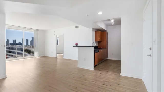 a view of a kitchen with wooden floor and windows