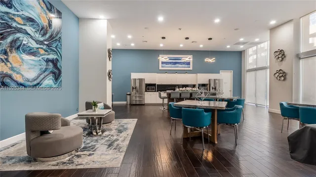 a kitchen with a sink a refrigerator and chairs