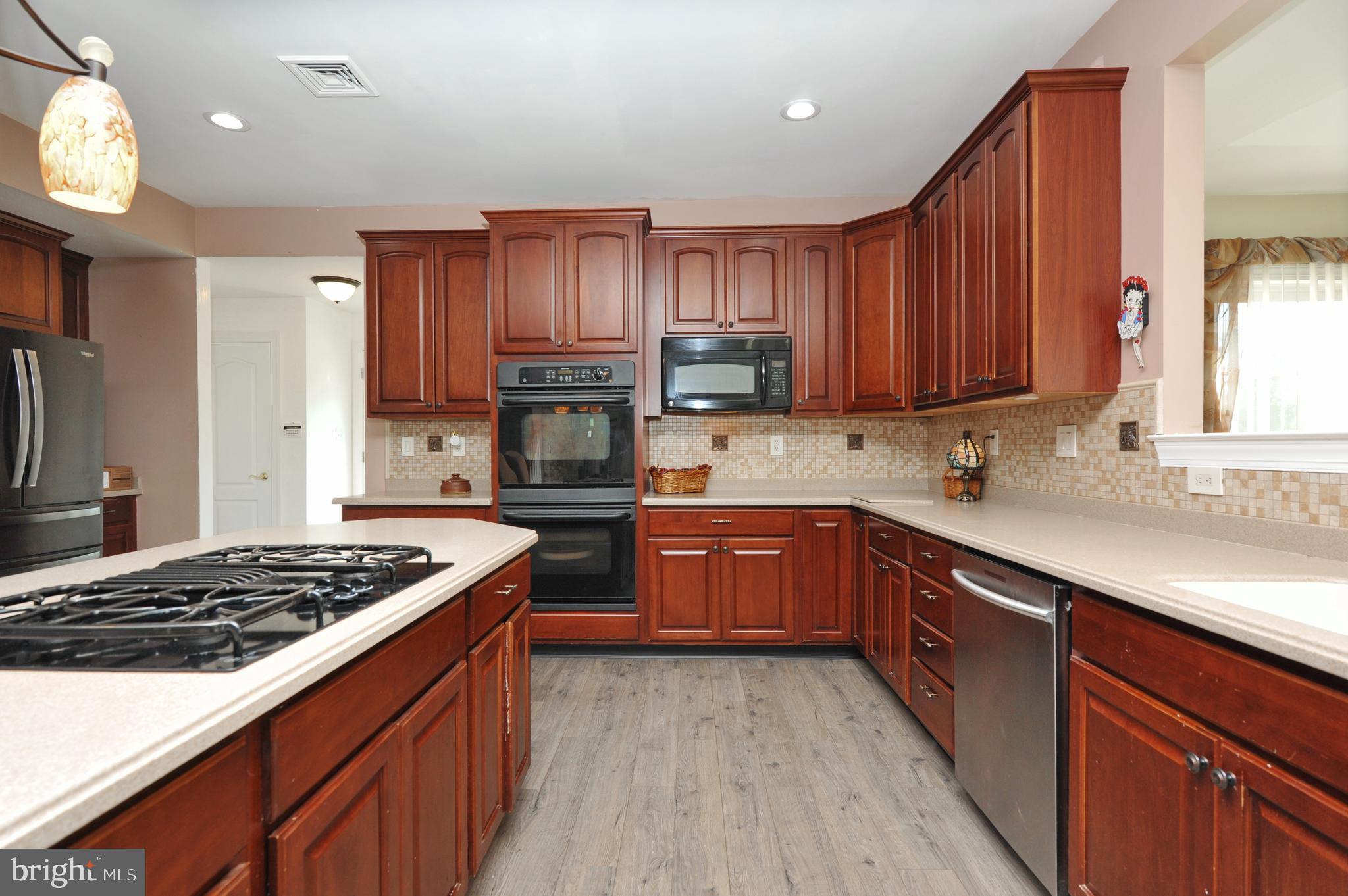 434 Hoffman Road Harleysville, PA 19438 - Photo 20 of 46 a kitchen with stainless steel appliances granite countertop a stove a sink dishwasher and a refrigerator with wooden cabinets