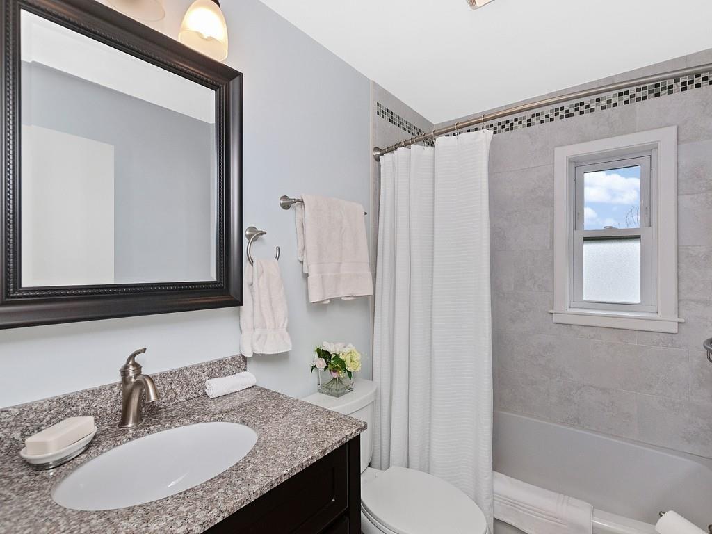 37 Slocum Road Boston, MA 02130 - Photo 16 of 27 a bathroom with a granite countertop sink toilet a mirror a vanity and shower