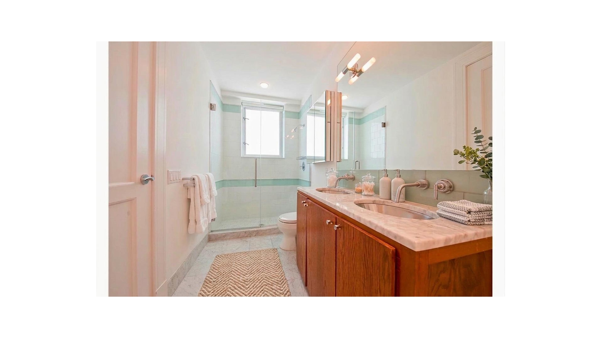 426 West 58th Street, Unit PH2 Manhattan, NY 10019 - Photo 5 of 11 a bathroom with a sink a toilet and a mirror