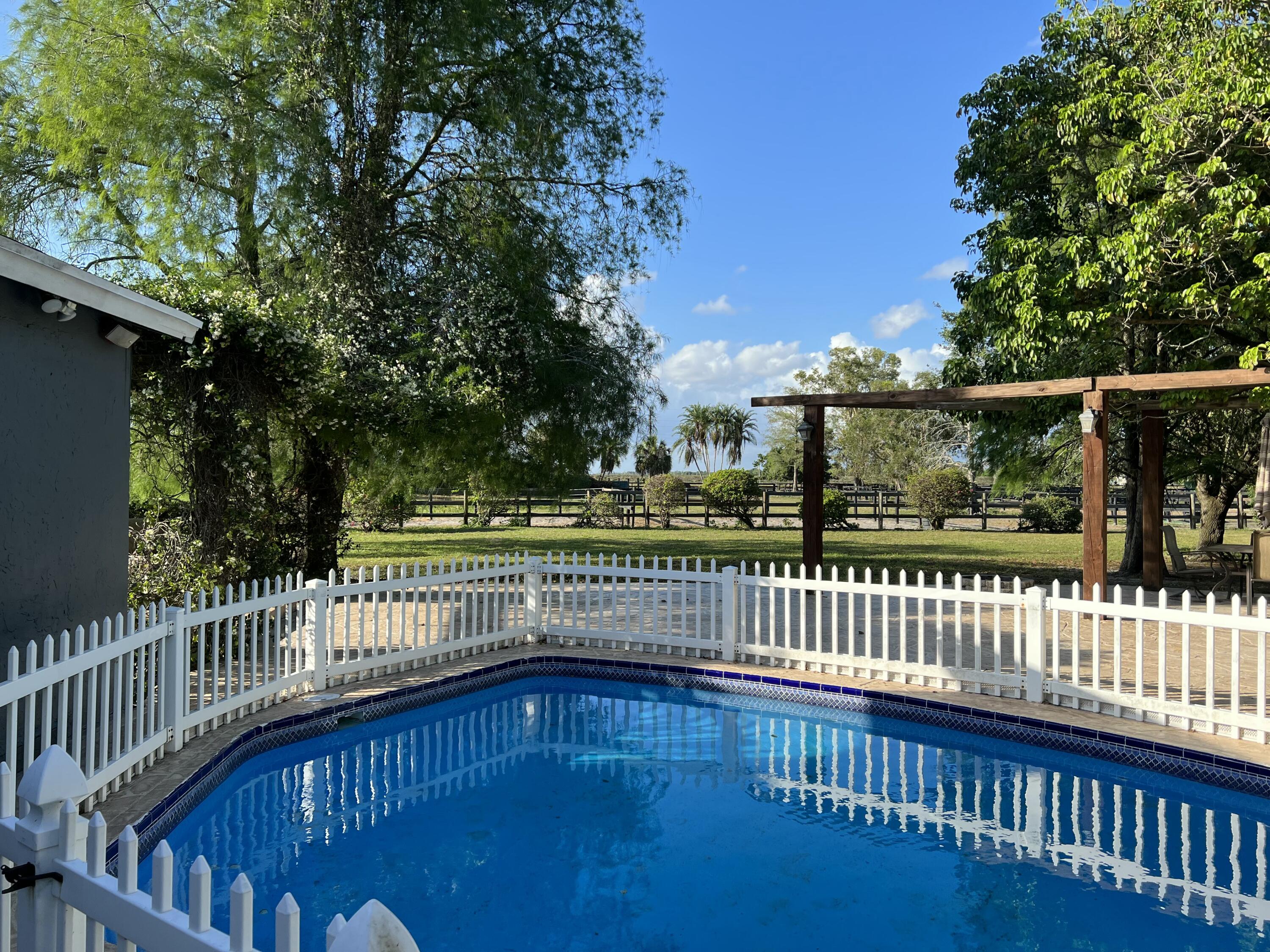16163 16097 Rustic Road Wellington, FL 33470 - Photo 20 of 36 a view of deck with a fence and trees