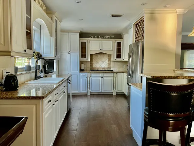 a kitchen with stainless steel appliances granite countertop a sink stove and refrigerator
