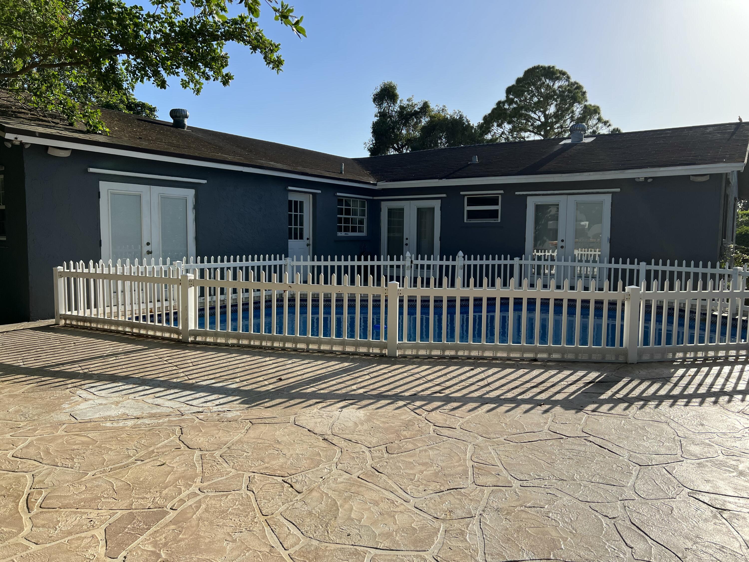 16163 16097 Rustic Road Wellington, FL 33470 - Photo 21 of 36 a front view of a house with a garden