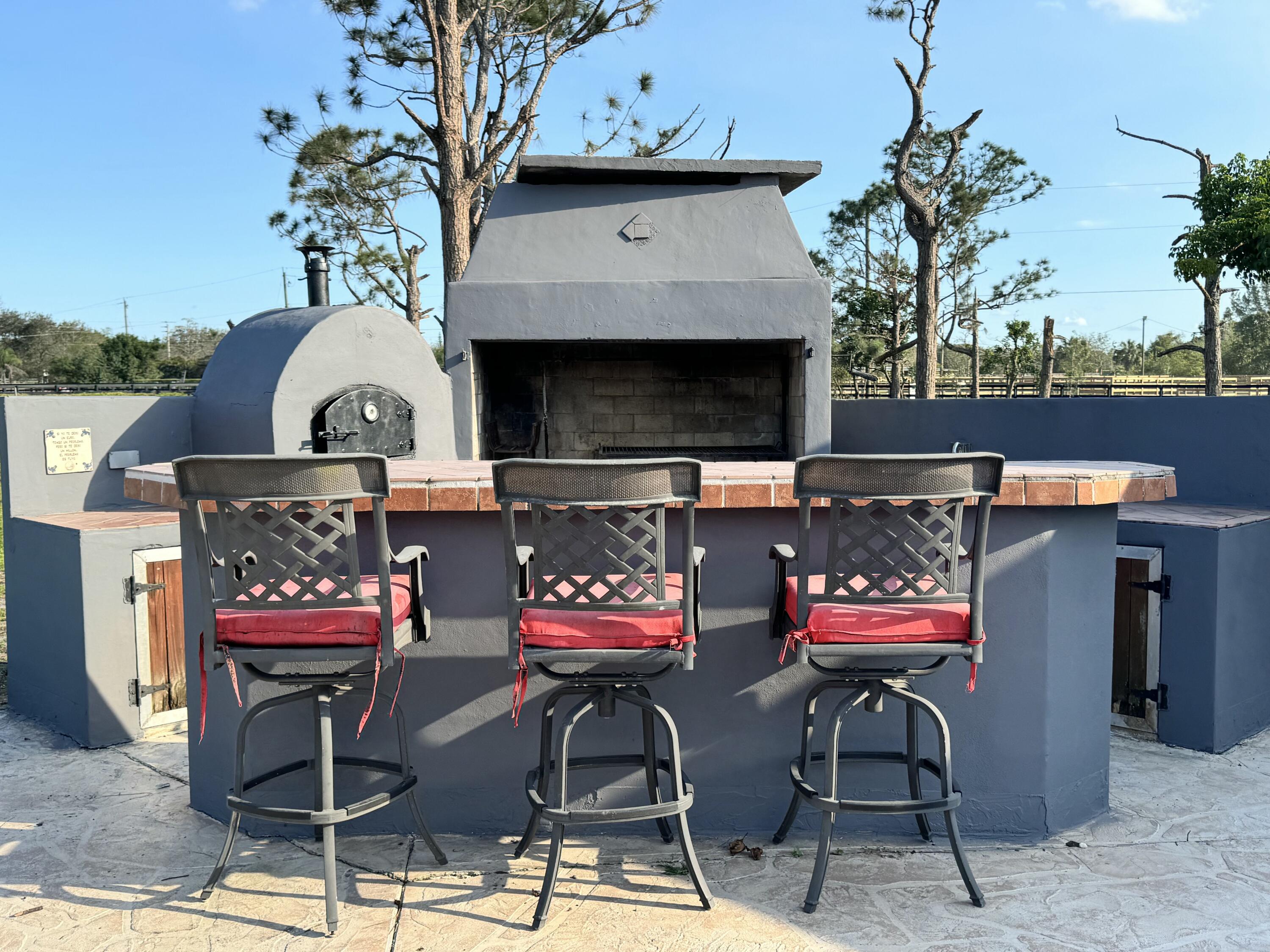 16163 16097 Rustic Road Wellington, FL 33470 - Photo 23 of 36 a store room with patio furniture and a fireplace