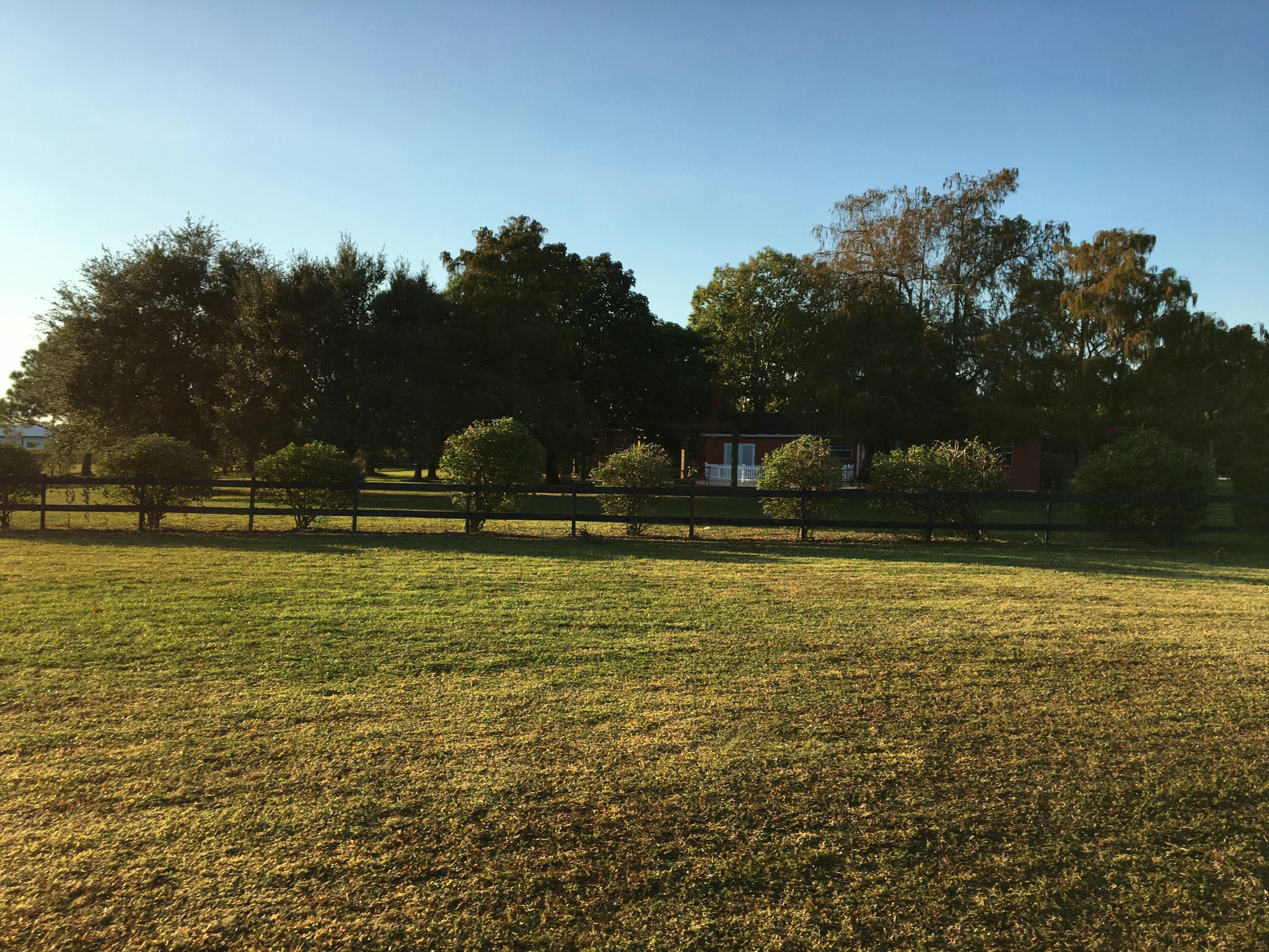 16163 16097 Rustic Road Wellington, FL 33470 - Photo 28 of 36 a view of outdoor space with swimming pool and trees