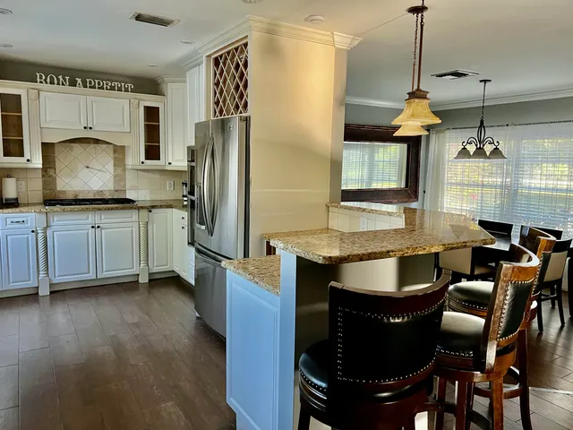 a kitchen with granite countertop a sink stainless steel appliances and cabinets